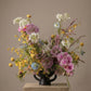 Colorful floral arrangement with orchids, allium, and mixed seasonal wildflowers
