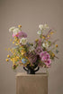 Colorful floral arrangement with orchids, allium, and mixed seasonal wildflowers