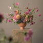 Artful seasonal flower arrangement with pink cosmos, dahlias, and garden blooms in a modern ceramic vase