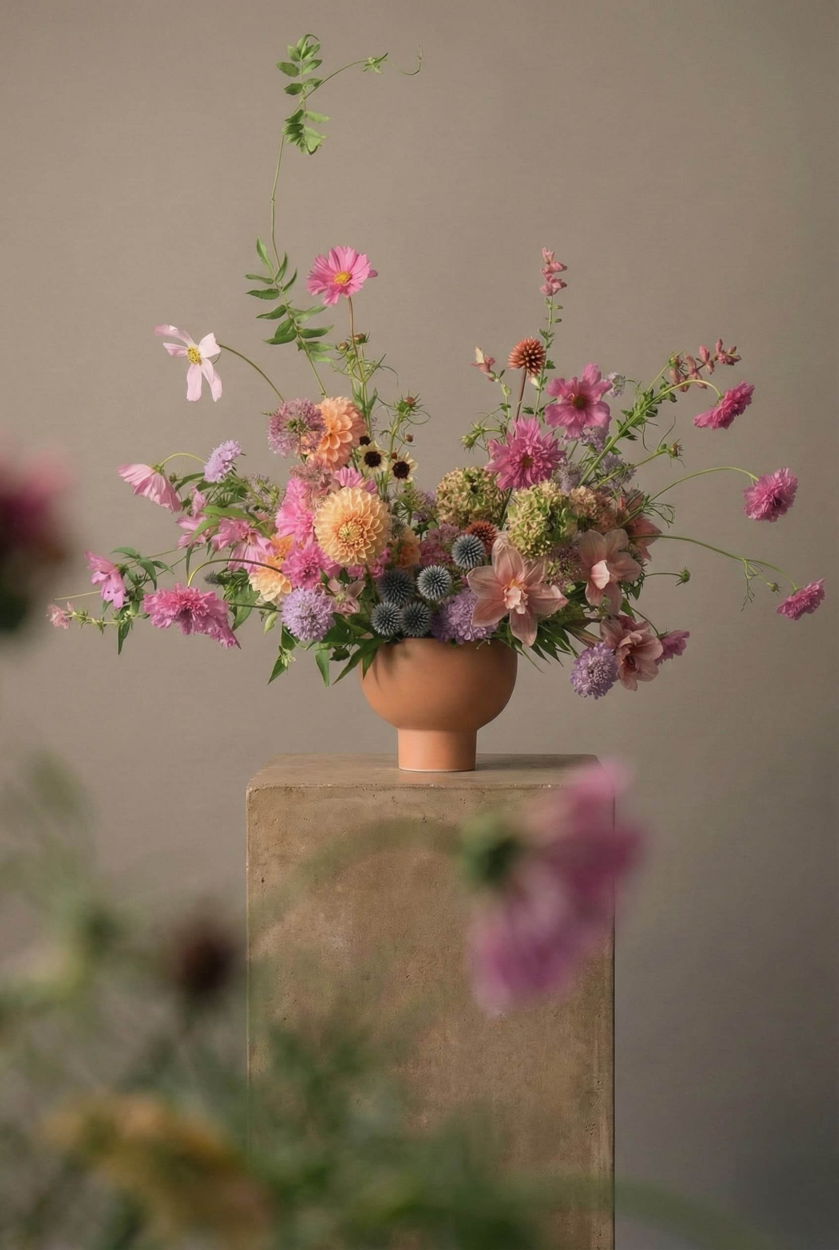 Artful seasonal flower arrangement with pink cosmos, dahlias, and garden blooms in a modern ceramic vase