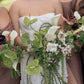 Bride and bridesmaid holding a bouquet with greenery and white flowers in Cherry Hills Country Club