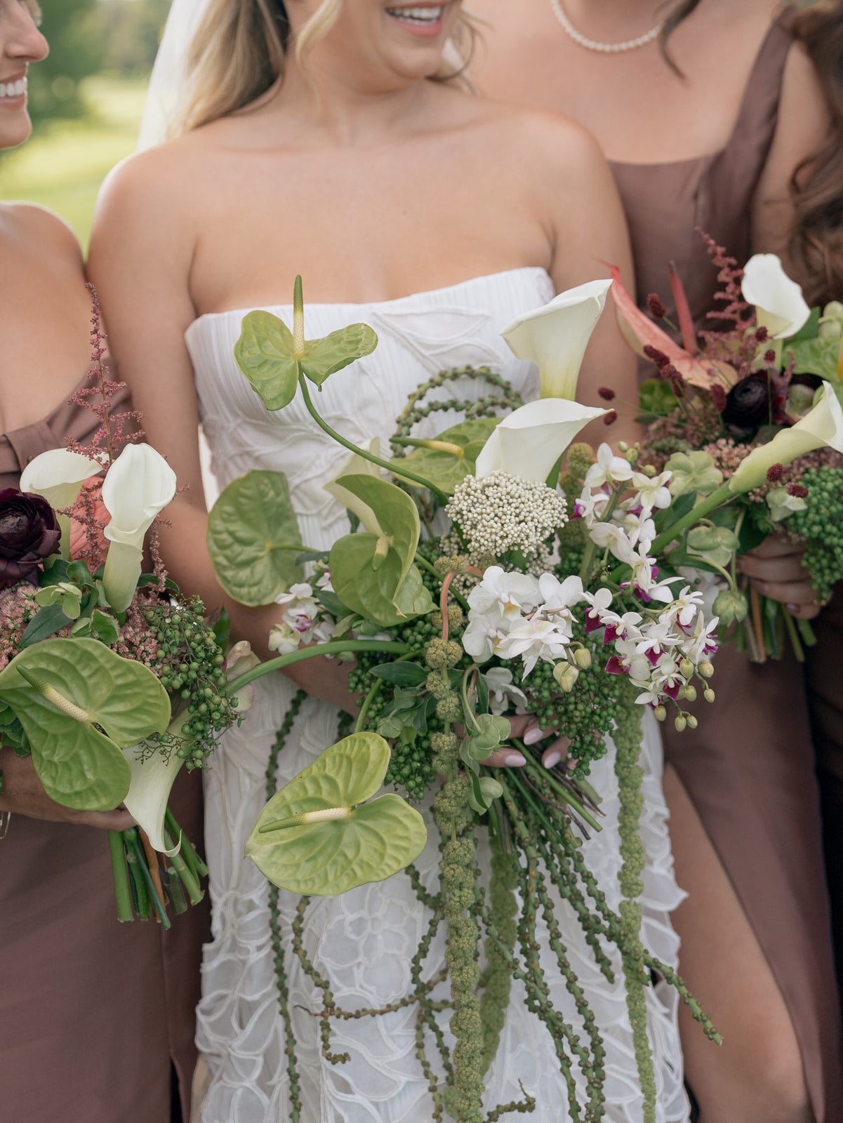 Bride and bridesmaid holding a bouquet with greenery and white flowers in Cherry Hills Country Club