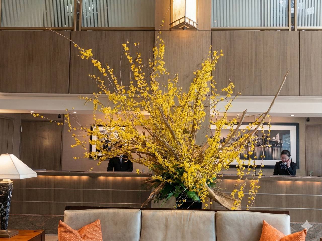Decorative yellow floral arrangement in a modern interior setting with a couch and lamp.