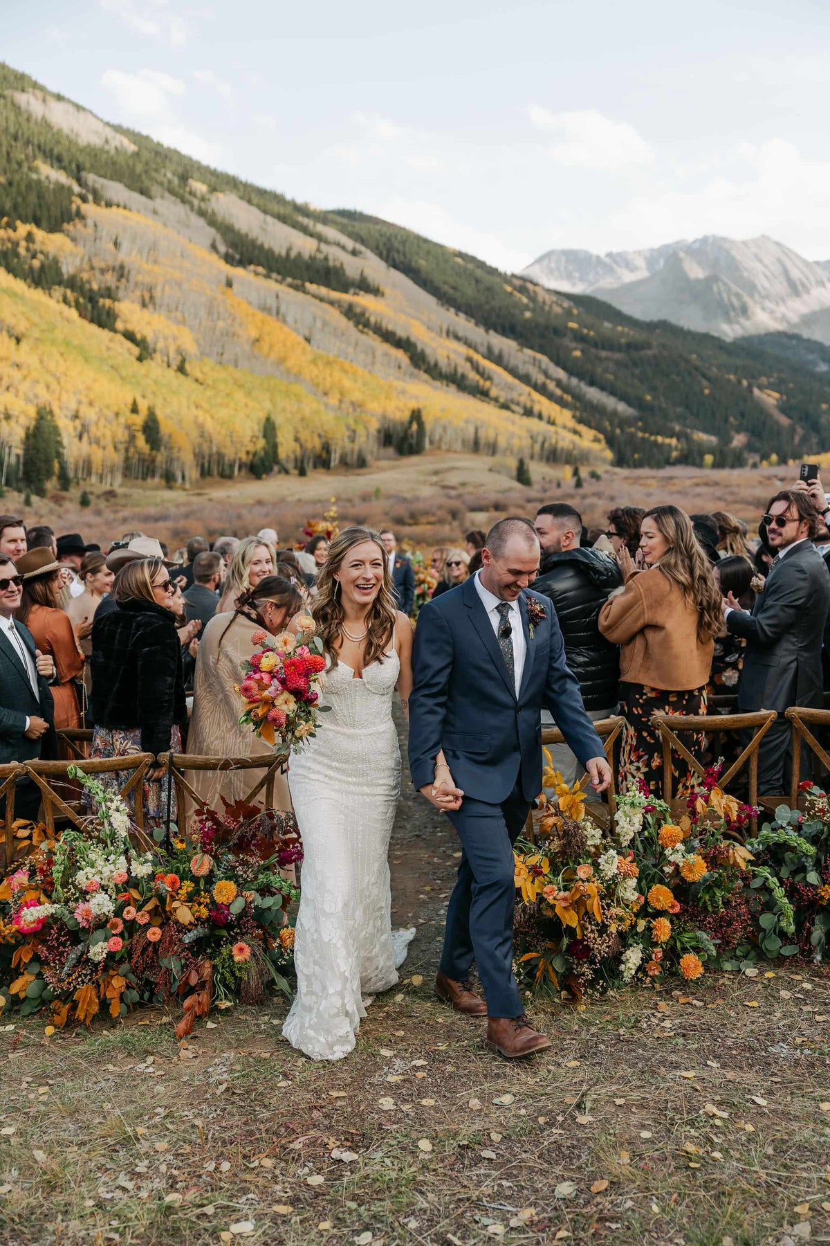 Wedding couple walking together with a mountainous landscape in Aspen Colorado wedding venues 