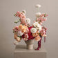 Romantic anniversary flower arrangement with blush roses, pink blooms, and red hydrangea in a modern ceramic vase
