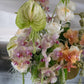Fresh Reverie floral arrangement featuring orchids and garden roses by Shaa.Project in a beautifully arranged display.