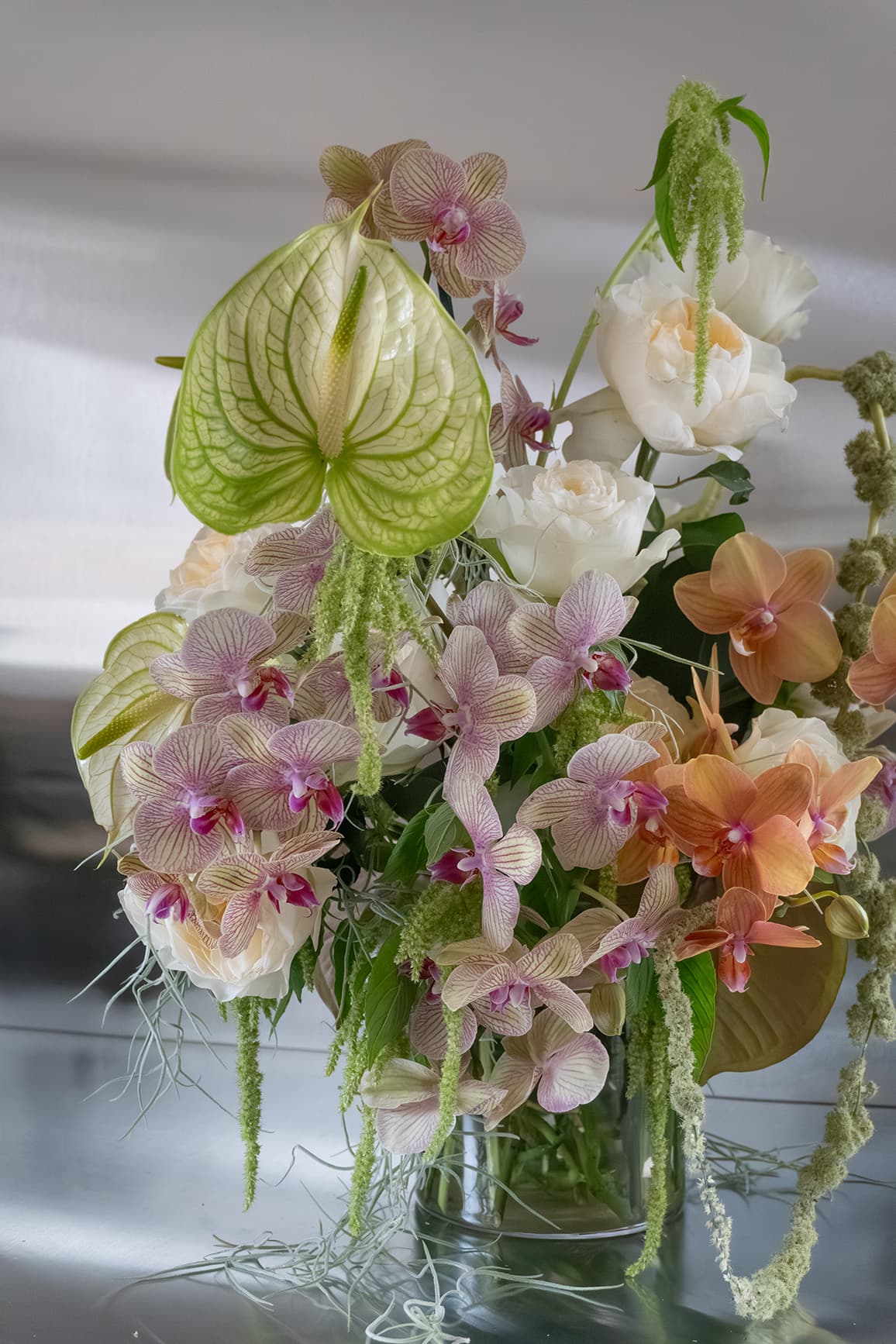 Fresh Reverie floral arrangement featuring orchids and garden roses by Shaa.Project in a beautifully arranged display.