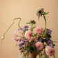 Seasonal designer’s choice flower arrangement with pink dahlias, clematis, and garden-style blooms