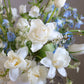 Close-up of Gentle Rise arrangement with white flowers and soft blue accents