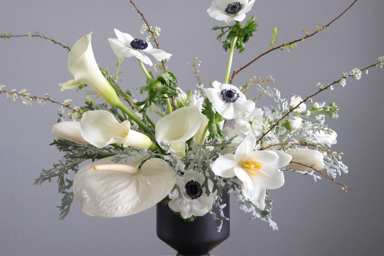 close-up of white sympathy flower arrangement with calla lilies and anemones by shaa.project