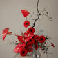 Shaa.Project sculptural red flower arrangement featuring vibrant red blooms in an artistic design.