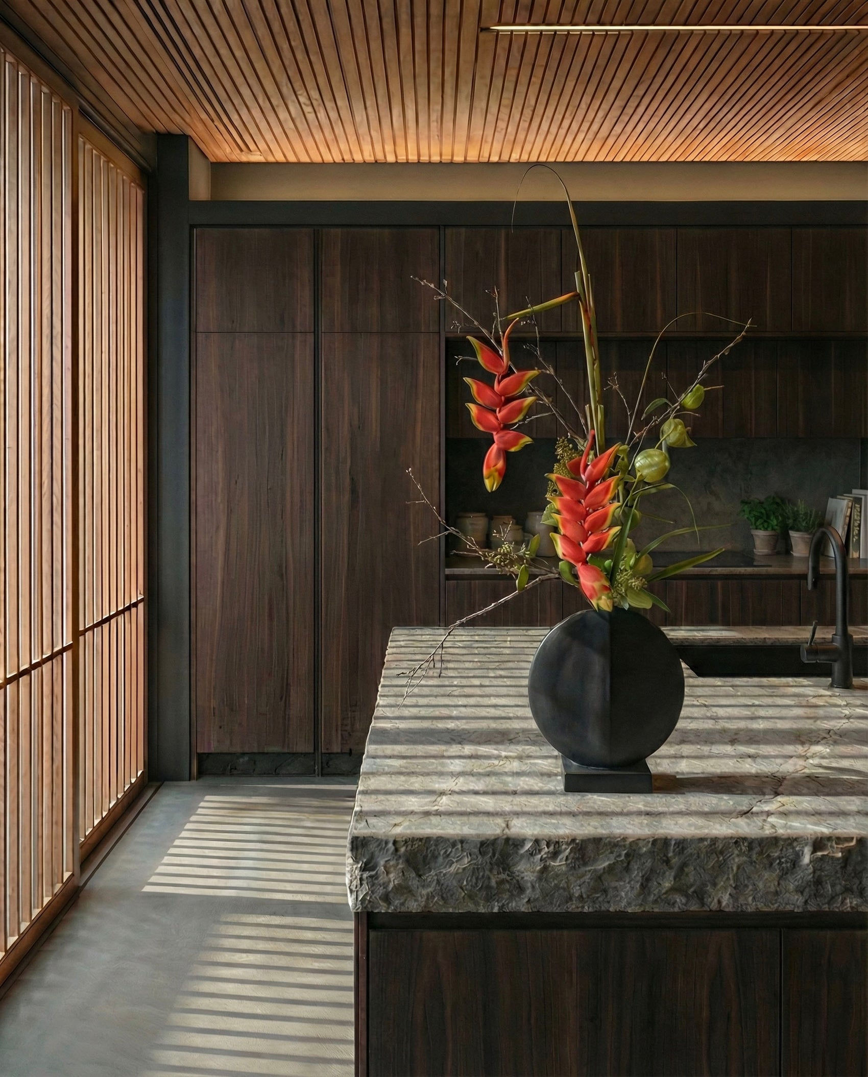Decorative vase with flowers on a marble countertop in a modern kitchen.