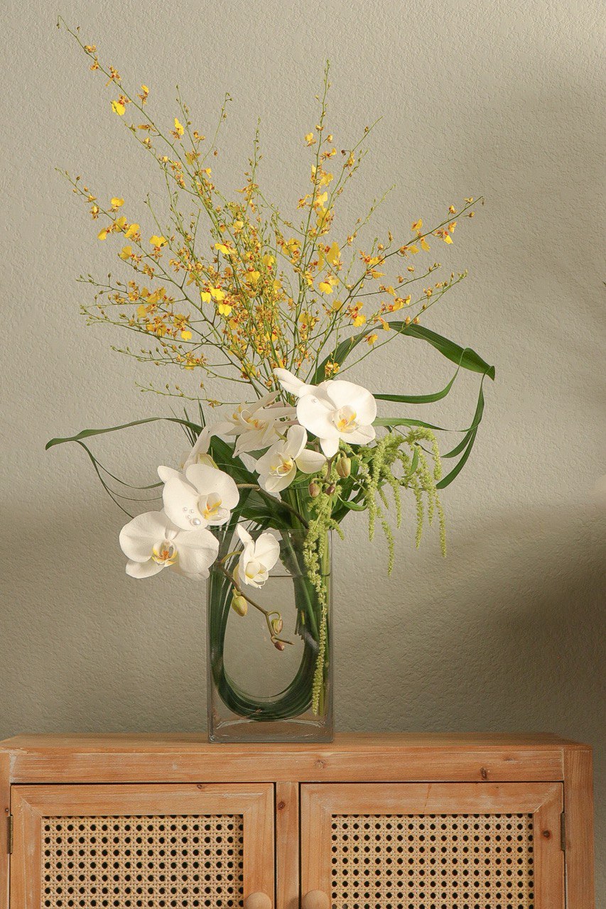 Shaa.Project Soft Ascent orchid arrangement with vibrant blooms in a stylish display for home decor.