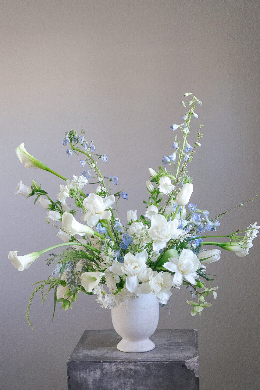 Shaa.Project Gentle Rise floral arrangement featuring sympathy flowers in soft colors, displayed in a serene setting.