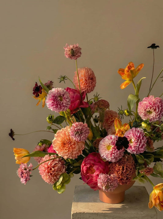 Sunburst colorful flower arrangement with dahlias and tulips in warm sunset tones