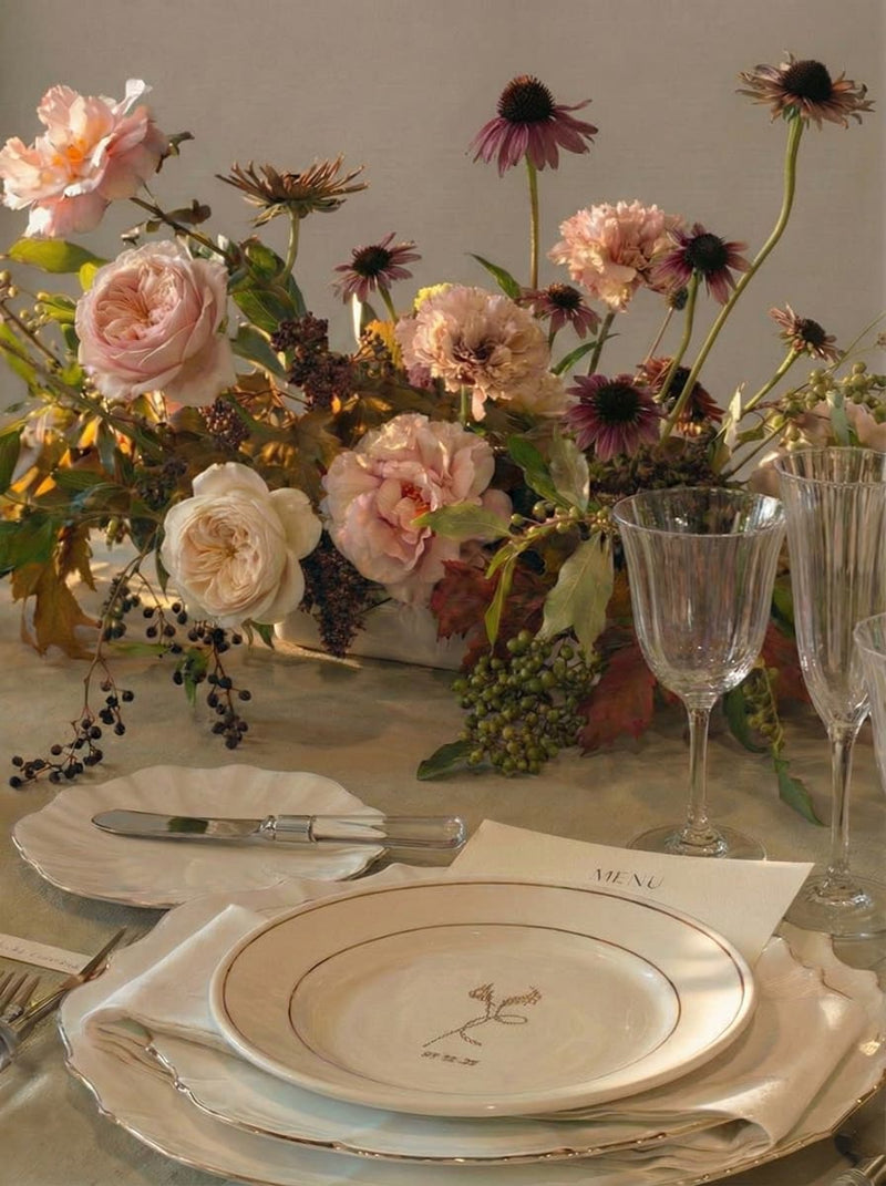 Elegant table setting with floral centerpiece, plates, cutlery, and glasses. Denver wedding and art studio