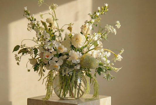 Airy white birthday flower arrangement with dahlias, orchids, and fresh greenery